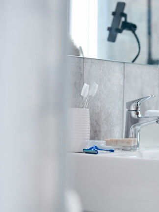 man washing face in a bathroom sink man washing face in a bathroom sink