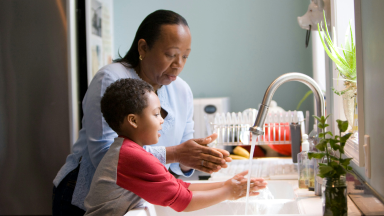 woman and child washing hands in a sink