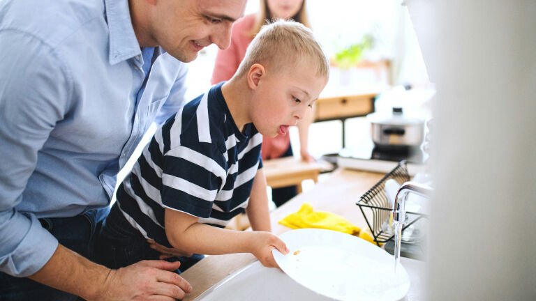 man and child washing dishes together